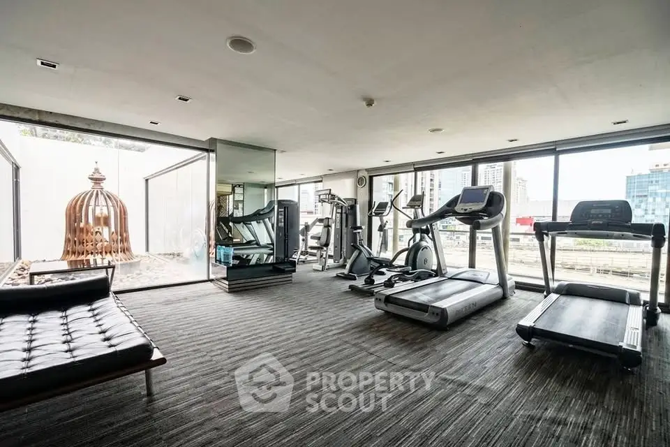 Modern gym with state-of-the-art equipment and city view, perfect for fitness enthusiasts.