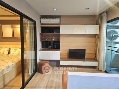 Modern living room with stylish wooden accents and sliding glass door to bedroom.