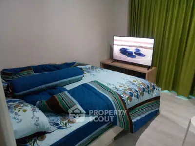Cozy bedroom with stylish bedding and modern TV setup