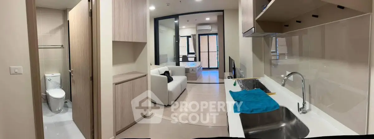 Modern open-plan apartment with sleek kitchen and cozy living area