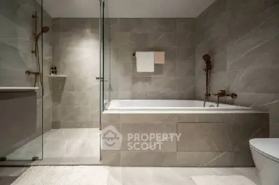 Luxurious modern bathroom with elegant bathtub and sleek glass shower enclosure.