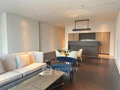 Spacious modern living room with elegant furniture and open kitchen layout.