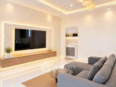 Modern living room with sleek design, featuring a large wall-mounted TV, stylish lighting, and cozy seating area.