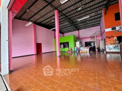 Spacious open-plan interior with vibrant colors and high ceilings, ideal for versatile use.