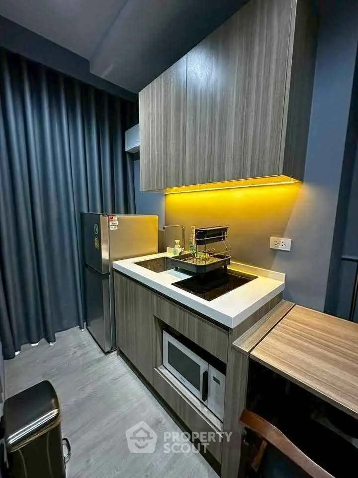 Modern compact kitchen with sleek cabinetry and integrated appliances in stylish apartment.