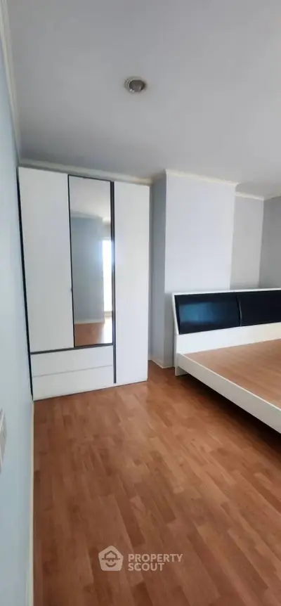 Spacious bedroom with modern wardrobe and sleek wooden flooring