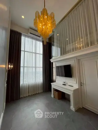 Elegant living room with high ceiling and modern chandelier in luxury apartment.