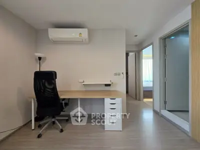 Modern study room with desk, chair, and air conditioning in a bright apartment.