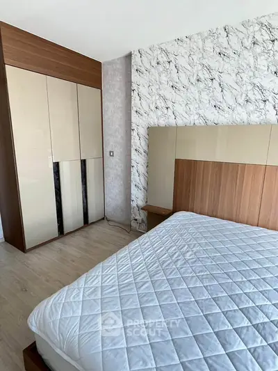Modern bedroom with stylish wardrobe and elegant marble accent wall