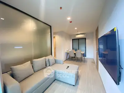 Modern living room with sleek furniture and large TV, perfect for relaxation.