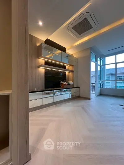 Spacious modern living room with elegant wood flooring and large windows