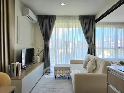 Modern living room with stylish decor and large windows offering natural light.