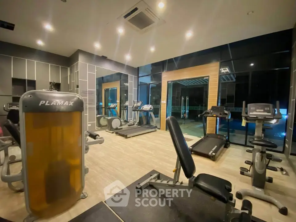 Modern gym with state-of-the-art equipment and large windows for natural light.