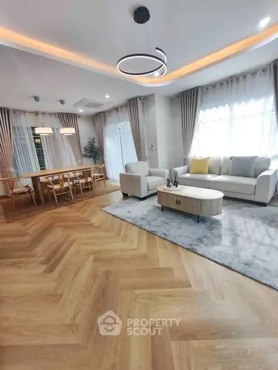 Spacious modern living room with elegant dining area and stylish lighting.