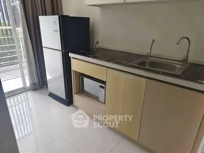 Modern kitchen with sleek appliances and balcony access in a stylish apartment.