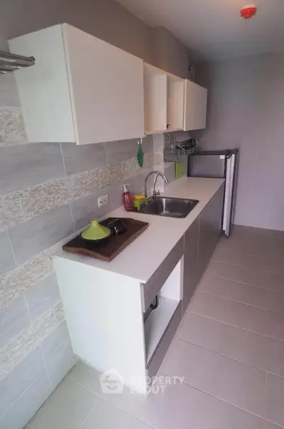 Modern kitchen with sleek cabinetry and compact appliances in a stylish apartment.