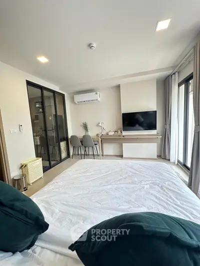 Modern bedroom with stylish decor and large windows for natural light.