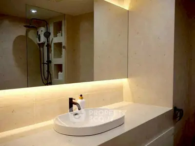 Modern bathroom with sleek sink and illuminated mirror