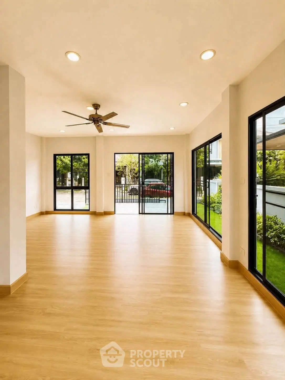 Spacious living room with large windows and garden view, perfect for natural light lovers.