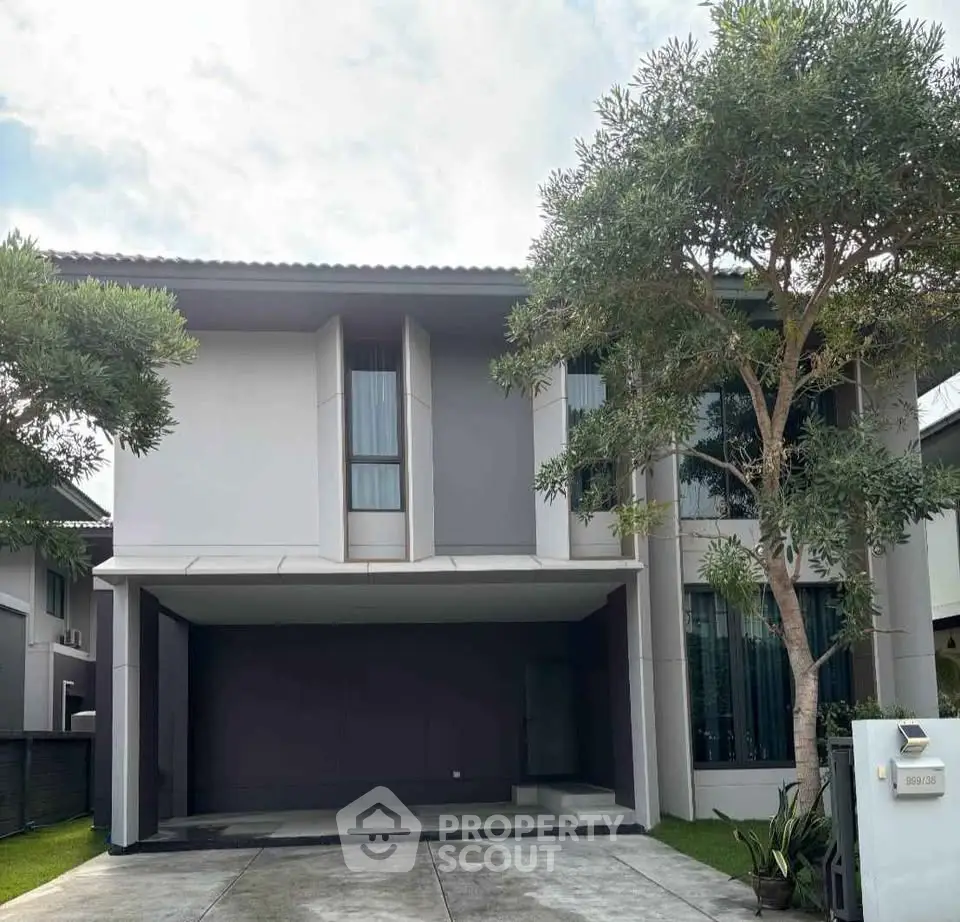 Modern two-story house with spacious driveway and lush greenery