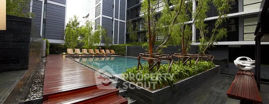 Luxurious modern apartment complex with serene pool and lush greenery, perfect for relaxation and leisure.