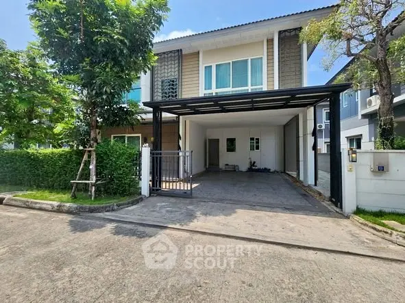 Modern two-story house with spacious driveway and lush greenery in a serene neighborhood.