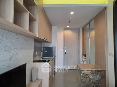 Modern kitchen with sleek wooden cabinetry and compact dining area
