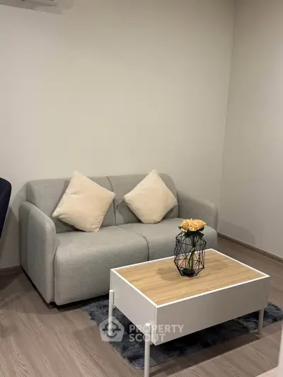 Cozy living room with modern gray sofa and stylish coffee table, perfect for relaxation.