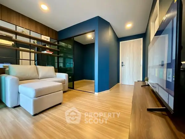 Modern living room with sleek blue walls and cozy beige sofa, featuring a stylish open layout.