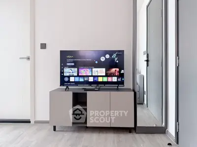 Modern living room with sleek TV setup and stylish cabinet in a contemporary apartment.