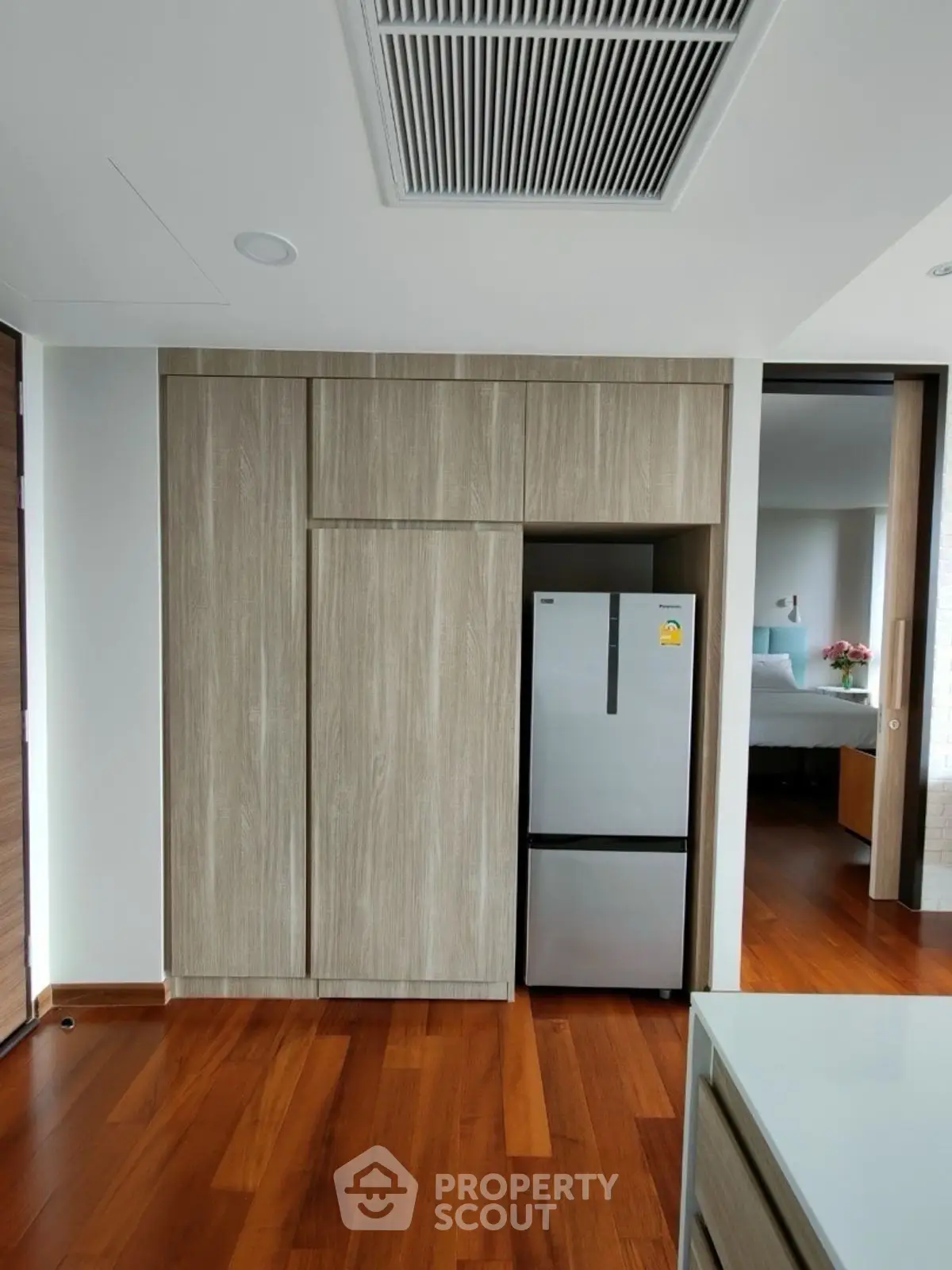 Modern kitchen with sleek wooden cabinetry and stainless steel fridge