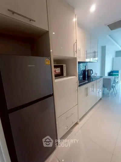 Modern kitchen with sleek appliances and dining area in open layout.