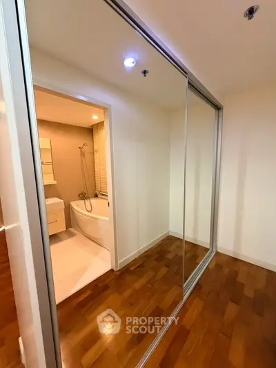Modern apartment with sleek bathroom and mirrored closet doors
