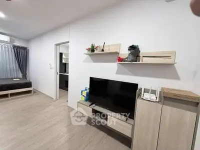 Modern living room with sleek TV unit and cozy bedroom view