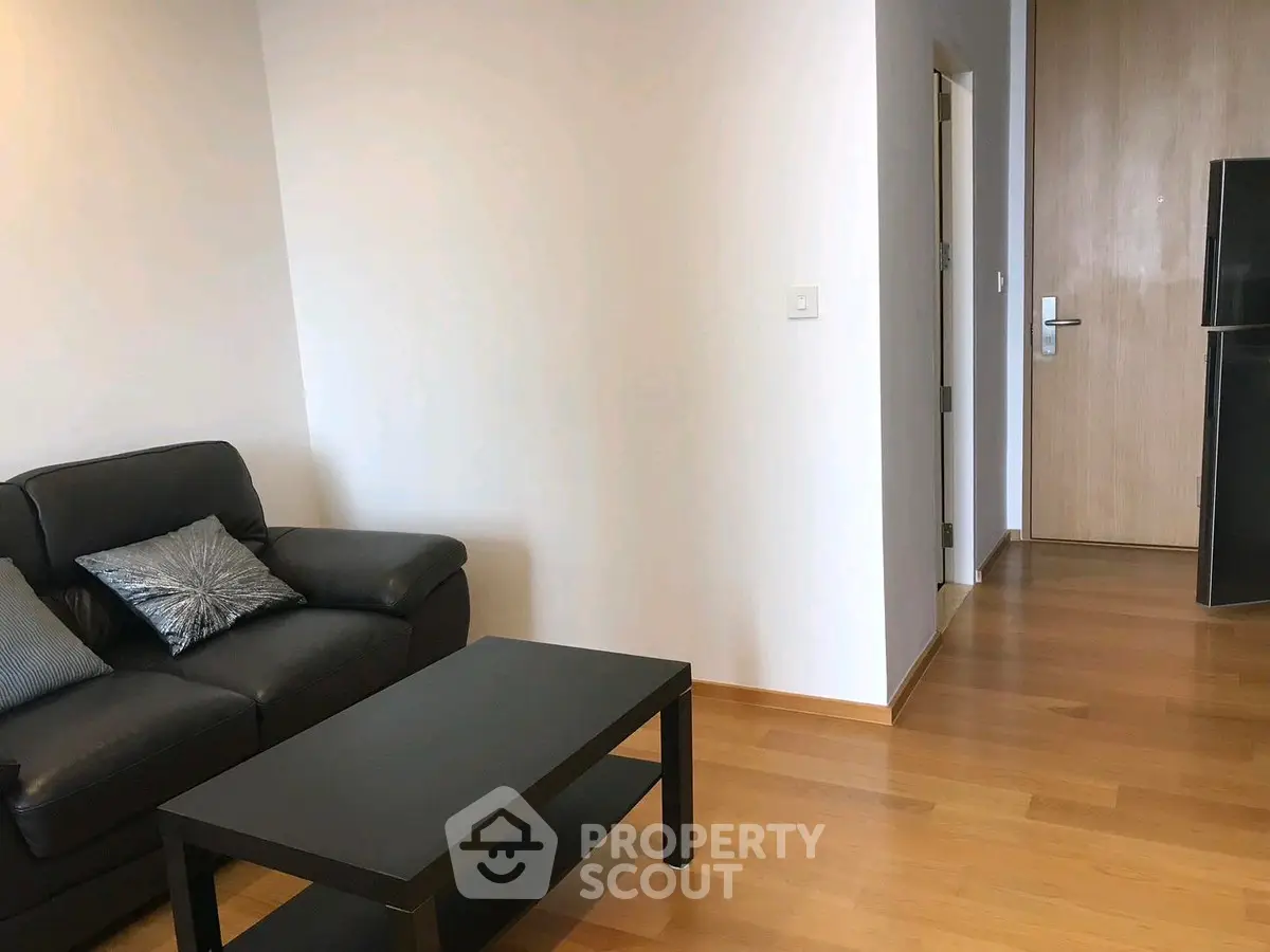 Modern living room with sleek black sofa and wooden flooring