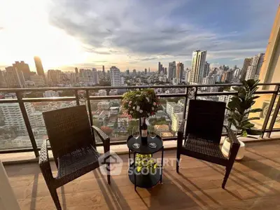 Stunning cityscape view from a high-rise balcony with elegant seating and decor.