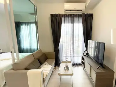Modern living room with sofa, TV, and balcony view in a stylish apartment.