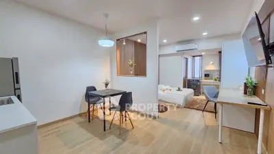 Modern open-plan living space with dining area and cozy bedroom, featuring stylish decor and ample natural light.