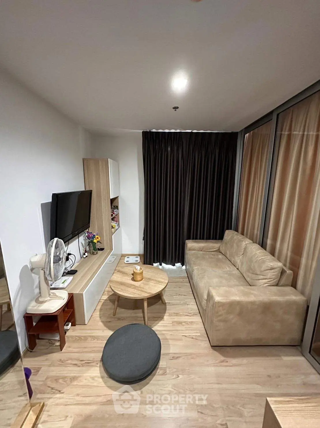 Cozy modern living room with beige sofa and sleek TV setup