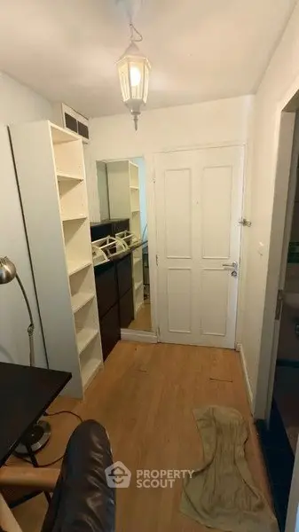 Cozy interior hallway with wooden flooring and built-in shelving, perfect for compact living spaces.