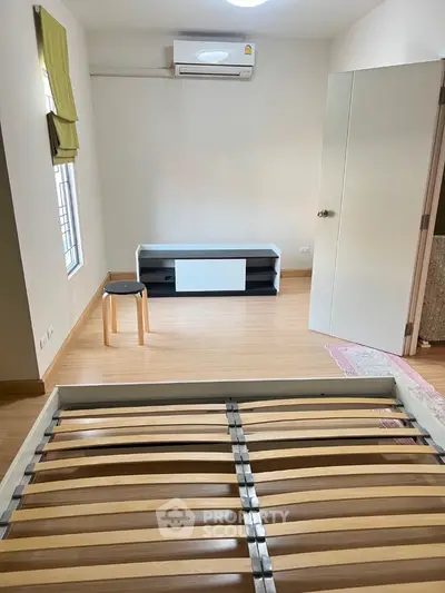 Spacious bedroom with air conditioning and modern wooden flooring