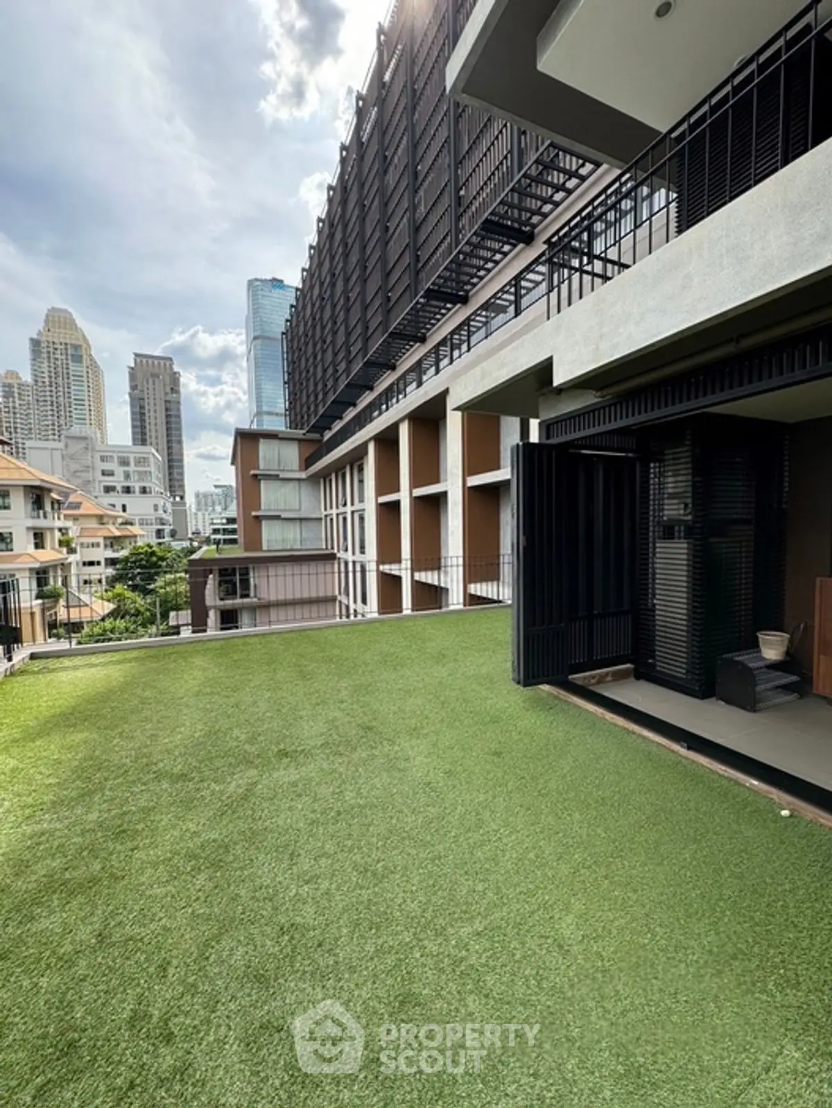 Modern urban building with spacious rooftop garden and city skyline view.