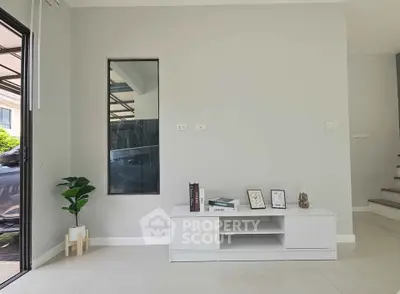 Modern minimalist living room with sleek white furniture and decorative accents.