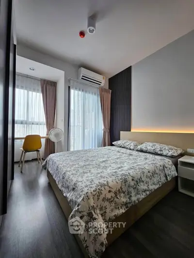 Modern bedroom with stylish decor, large windows, and cozy ambiance in a contemporary apartment.