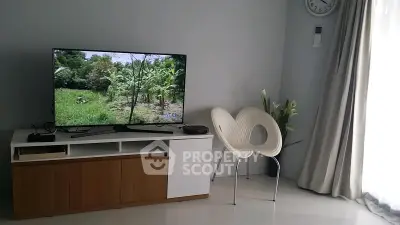 Modern living room with sleek TV setup and stylish chair, perfect for relaxation and entertainment.
