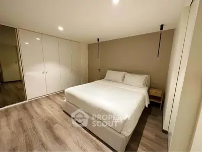 Spacious modern bedroom with sleek design and ample storage space.