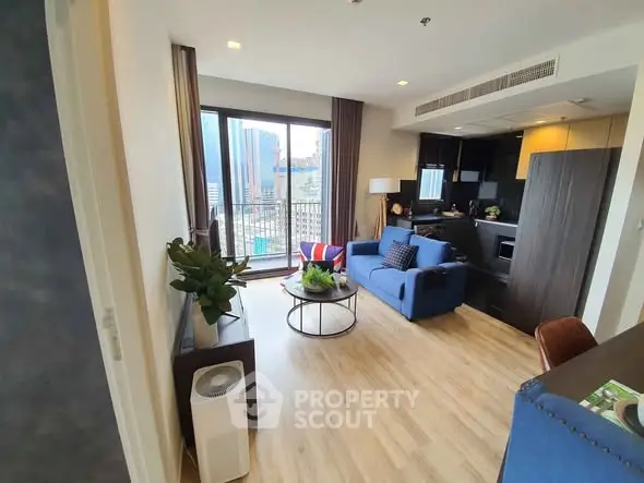 Modern living room with city view, stylish furniture, and open kitchen layout.
