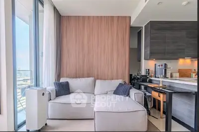Modern living room with cozy sofa and open kitchen layout in a bright apartment.
