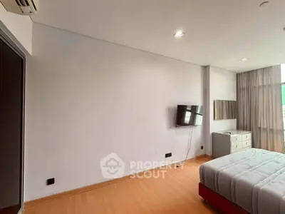 Spacious bedroom with modern decor and natural light