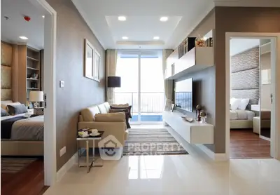 Modern living room with elegant decor and open layout leading to a cozy bedroom.